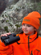 Charger l'image dans la galerie, Enfant portant le bonnet brodé TAYAUT orange, jumelles de chasse à la main